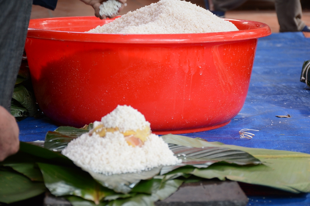 Khi gói bánh, một lớp gạo nếp được đổ trên lá bánh rồi cho nhân bánh.